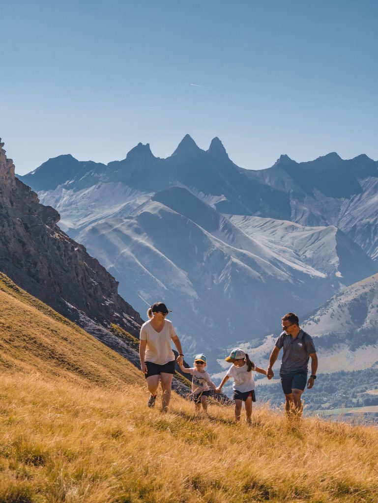 Photo d'une famille de face qui fait une randonnée au corbier avec vue sur les Aiguilles d'Arves
